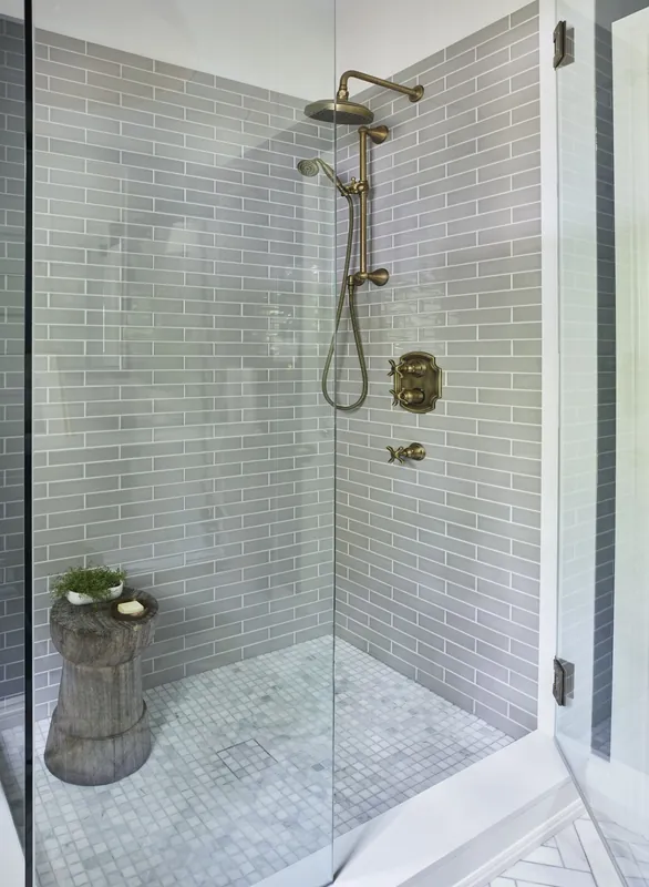 Marble tiled walk in shower with a glass enclosure