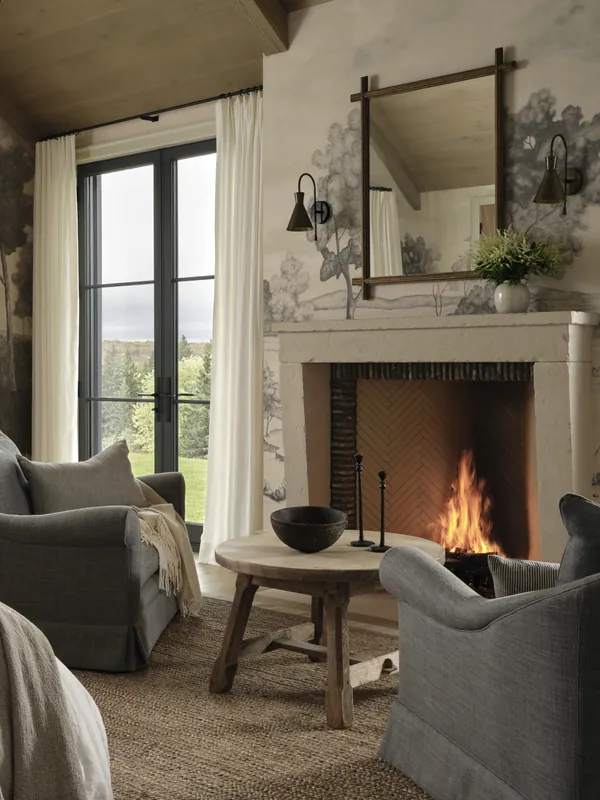 Farmhouse bedroom sitting area around a cut stone fireplace