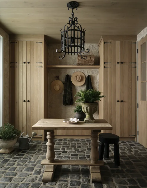 Farmhouse mudroom with a cobblestone floor and built in timber cabinetry