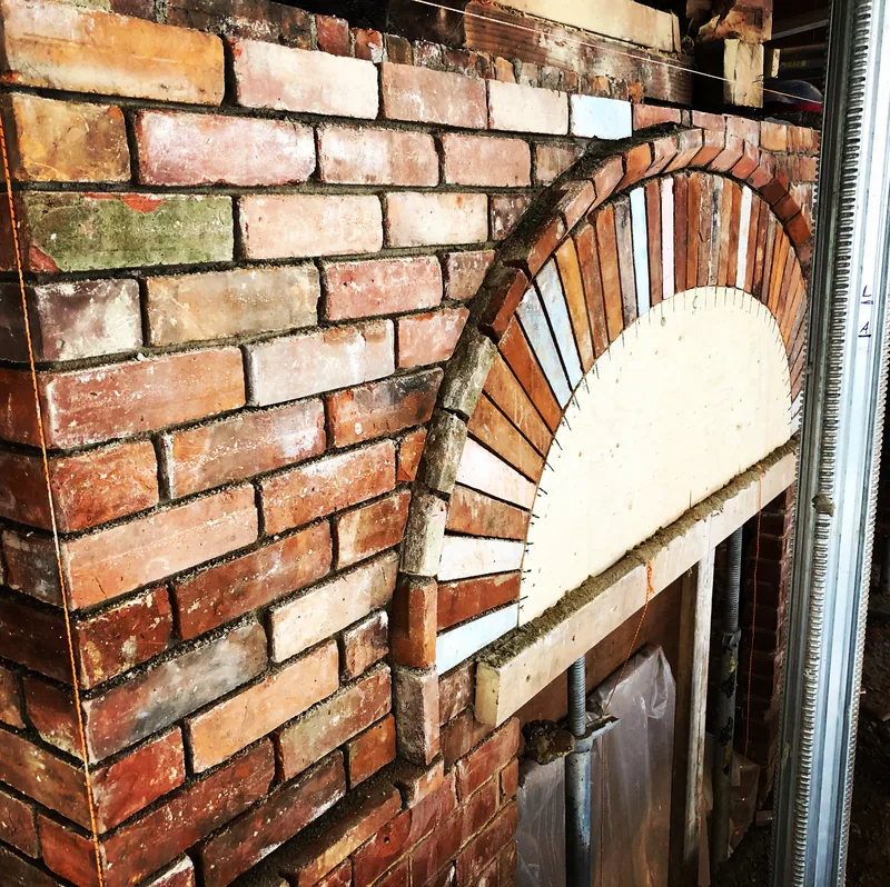 Segmental brick arch rebuilt in reclaimed brick on a Toronto home
