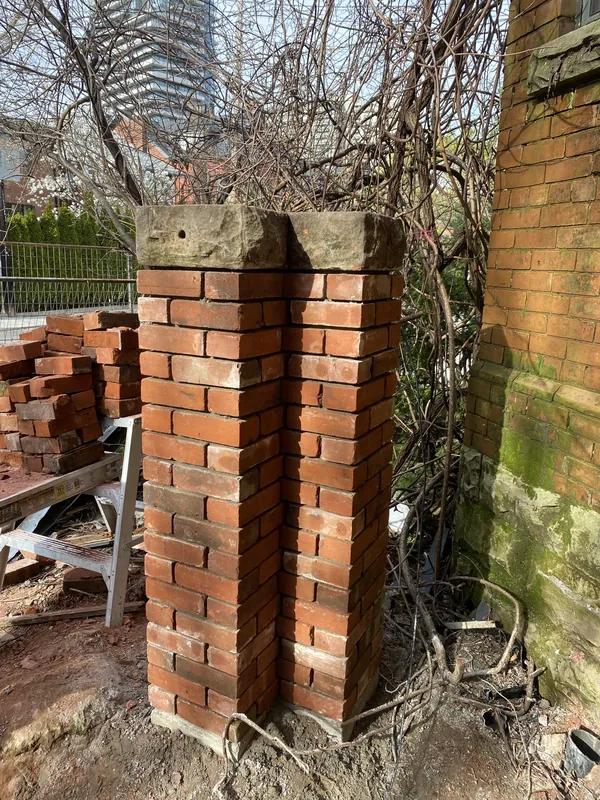 Brick gate pillars rebuilt with their original stone caps in Toronto