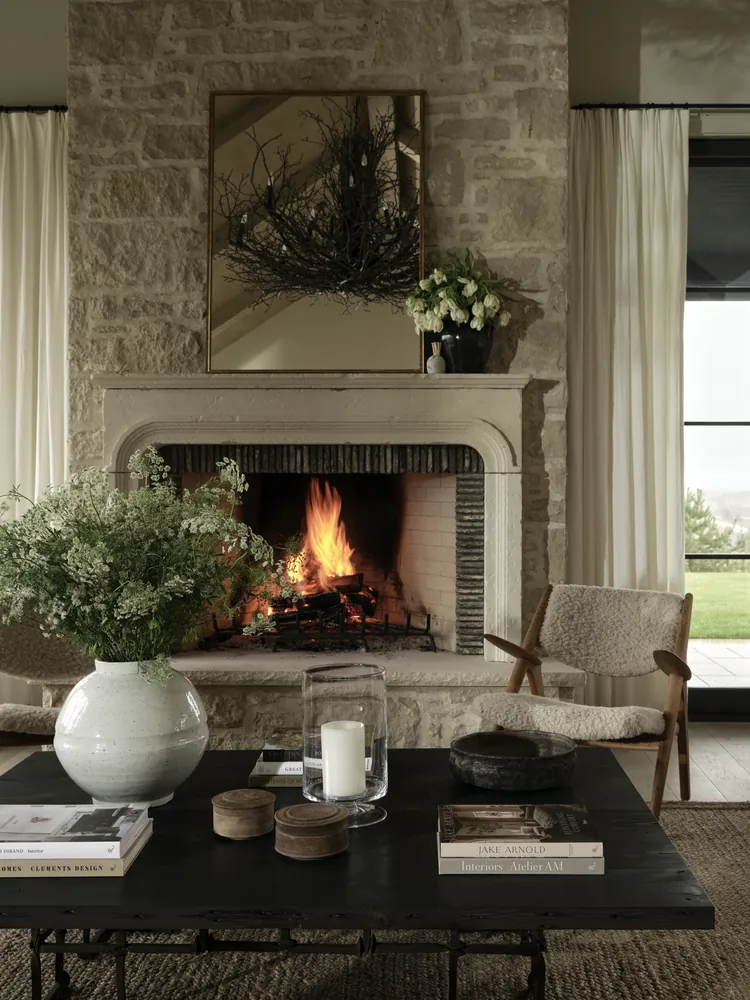 Limestone fireplace surround set against a natural stone feature wall